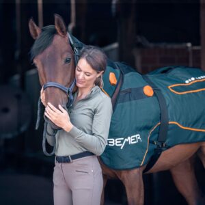 Paard draagt BEMER-therapiedeken om de doorbloeding te stimuleren via pulserende elektromagnetische therapie voor herstel en ontspanning.